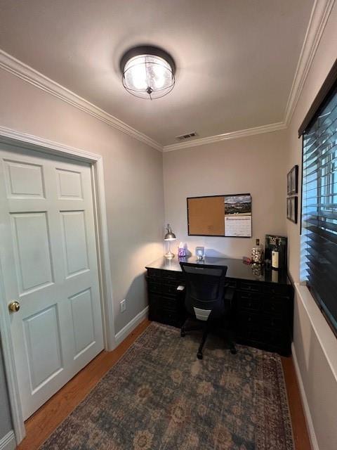 home office featuring baseboards, ornamental molding, wood finished floors, and visible vents