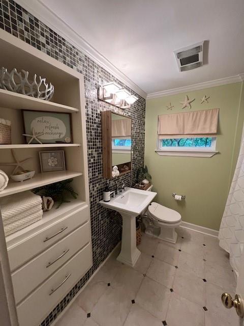 bathroom with visible vents, ornamental molding, built in features, and toilet