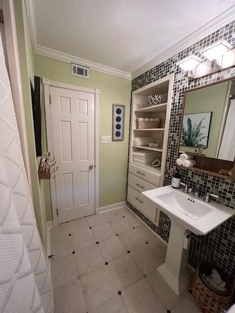 bathroom featuring crown molding, baseboards, backsplash, and visible vents