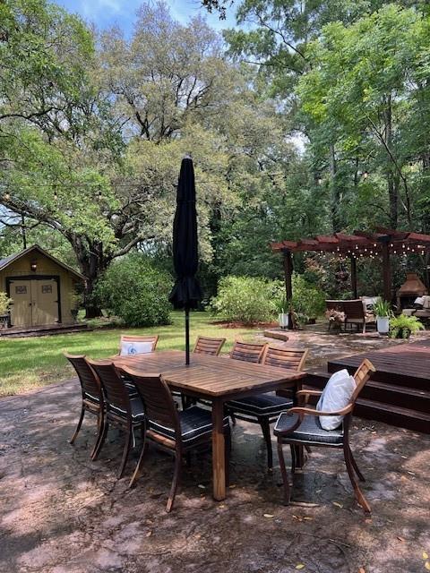 view of patio / terrace featuring outdoor dining area, an outdoor structure, a pergola, and a deck