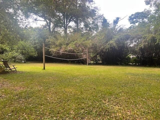 surrounding community with a lawn and volleyball court