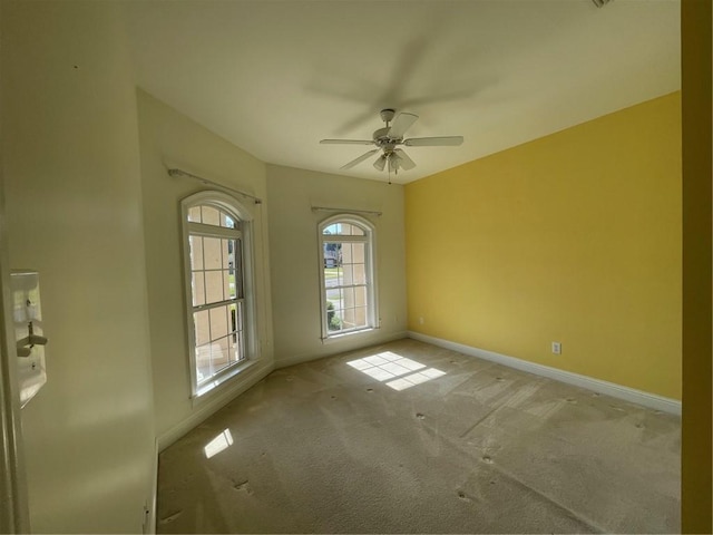 carpeted spare room featuring ceiling fan