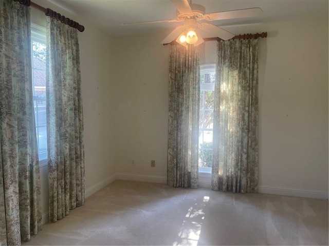 empty room with light colored carpet and ceiling fan