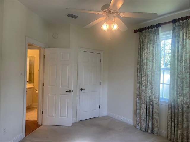 unfurnished bedroom with light carpet, a closet, and ceiling fan