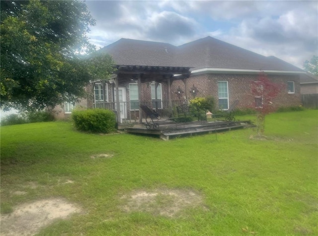 rear view of property with a pergola and a lawn