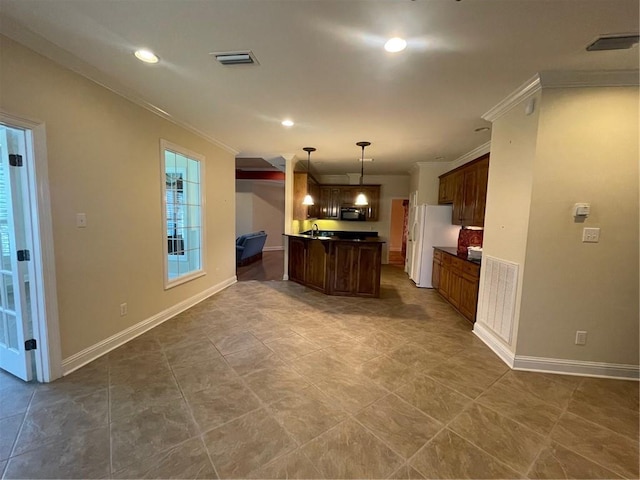 kitchen with white refrigerator, ornamental molding, a kitchen island, and pendant lighting