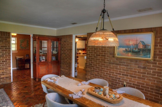 dining room with visible vents, brick wall, ornamental molding, and brick floor