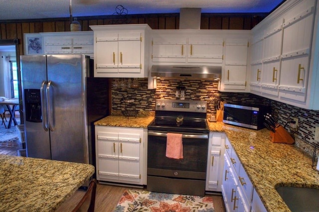kitchen with white cabinets, backsplash, stainless steel appliances, and extractor fan