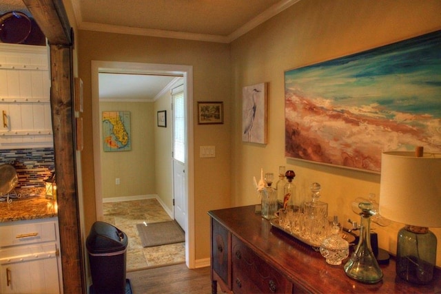 hall featuring ornamental molding, dark wood-style floors, and baseboards