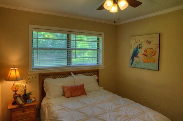 bedroom with ornamental molding and ceiling fan