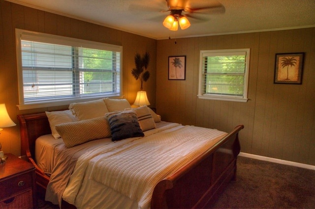bedroom featuring ornamental molding, a ceiling fan, dark colored carpet, and baseboards