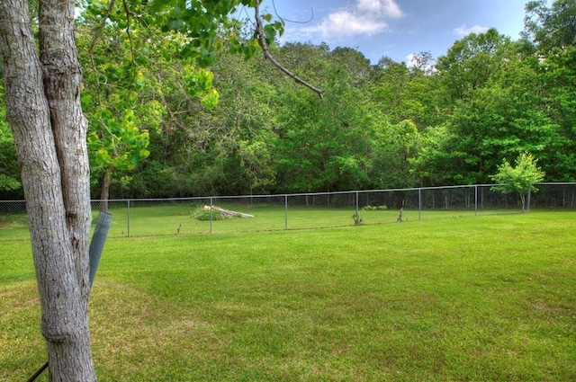 view of yard with fence and a view of trees