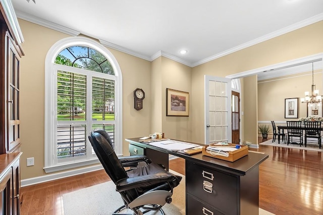 office area with dark wood-type flooring, ornamental molding, and an inviting chandelier