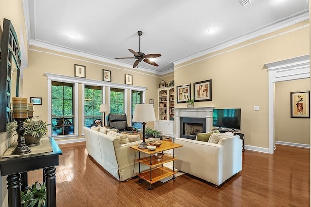 living room featuring ceiling fan, ornamental molding, and wood-type flooring