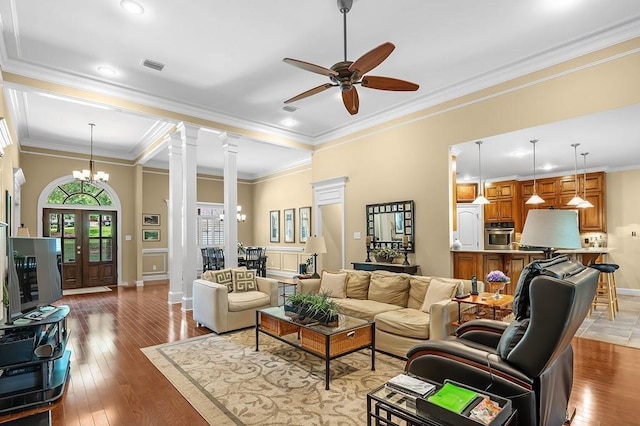 living room featuring crown molding, hardwood / wood-style flooring, decorative columns, and french doors