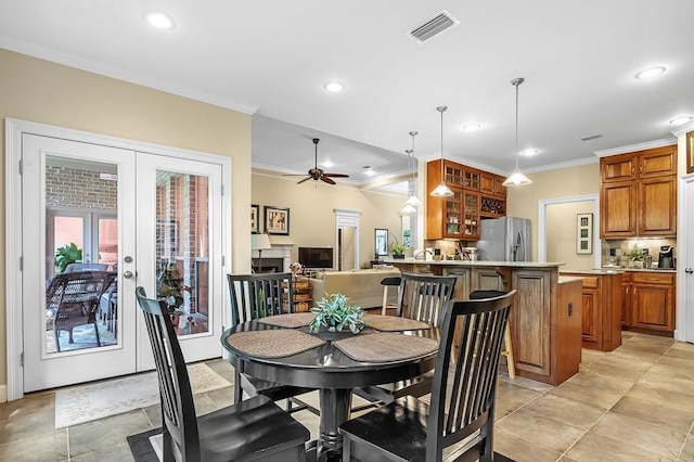 dining area with ornamental molding, ceiling fan, and french doors