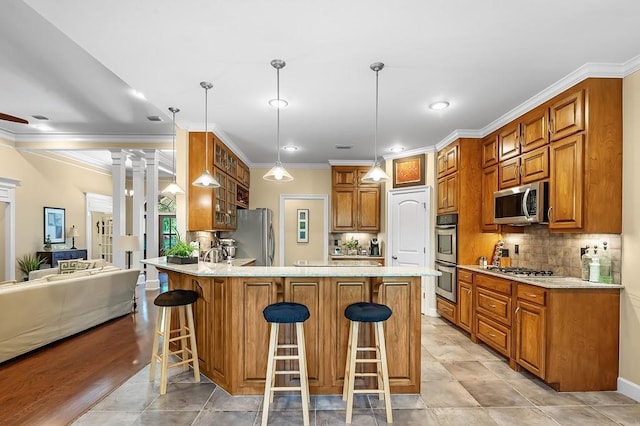 kitchen with tasteful backsplash, stainless steel appliances, a kitchen bar, and hanging light fixtures