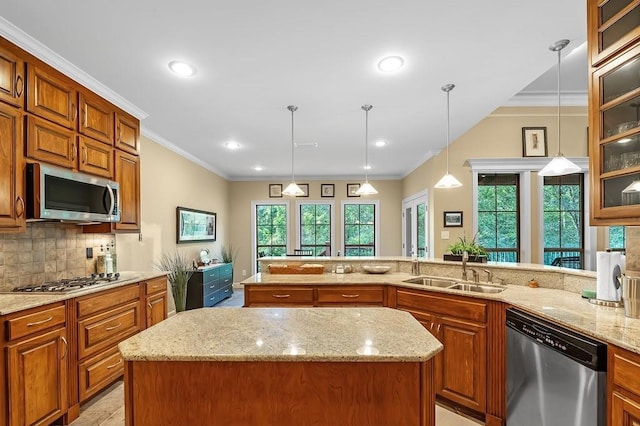 kitchen with appliances with stainless steel finishes, a center island, sink, and pendant lighting