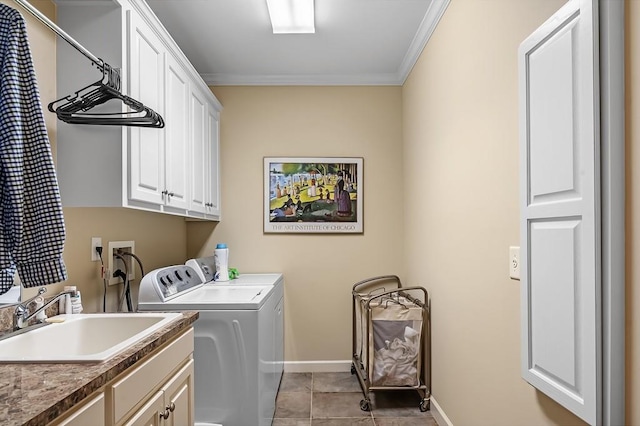 laundry room featuring washing machine and clothes dryer, sink, crown molding, cabinets, and light tile patterned floors