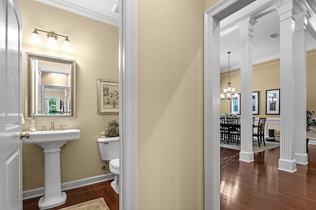 bathroom with wood-type flooring, ornamental molding, toilet, and ornate columns