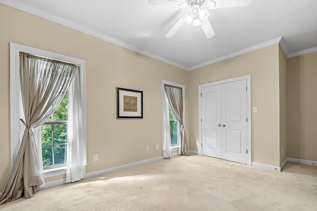 interior space featuring crown molding, light colored carpet, and ceiling fan