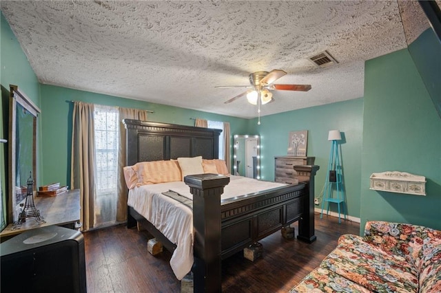 bedroom featuring dark hardwood / wood-style floors, a textured ceiling, and ceiling fan