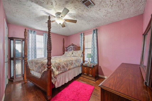 bedroom featuring ceiling fan, dark hardwood / wood-style flooring, and a textured ceiling