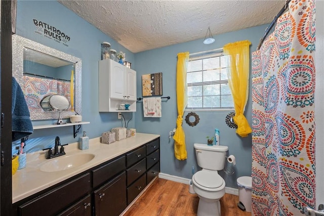 bathroom featuring toilet, wood-type flooring, a textured ceiling, vanity, and a shower with shower curtain