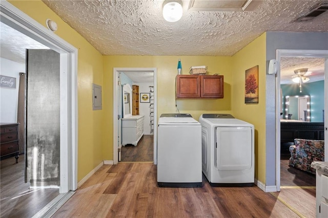 laundry area with separate washer and dryer, hardwood / wood-style floors, cabinets, and a textured ceiling