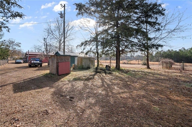 view of yard featuring a rural view and a storage unit