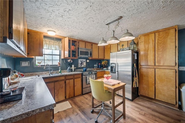 kitchen with pendant lighting, sink, dark wood-type flooring, and stainless steel appliances