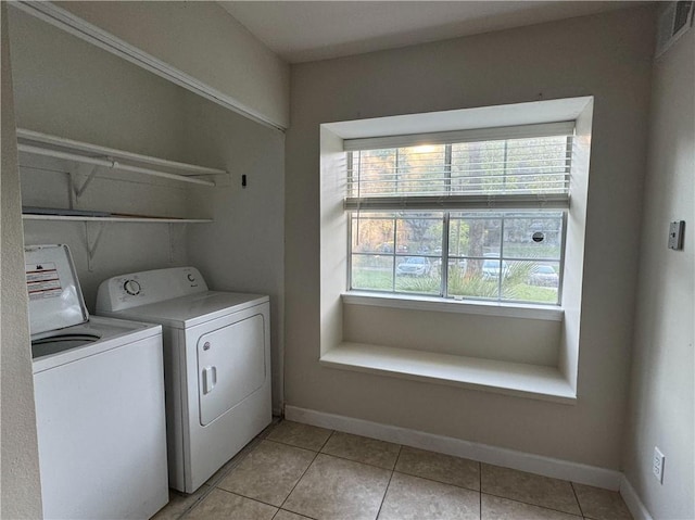 clothes washing area featuring washer and clothes dryer and light tile patterned floors