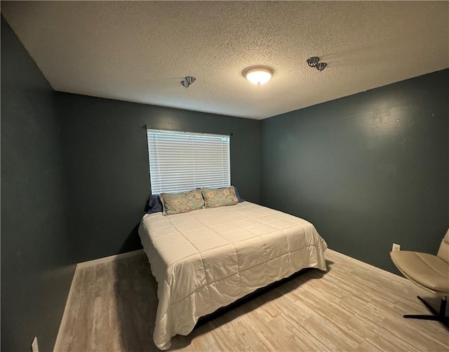 bedroom with wood-type flooring and a textured ceiling