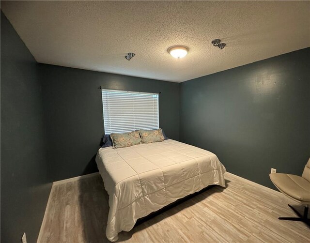 6701 Dickens Ferry Rd Unit 22, Mobile, AL 36608 - bedroom featuring a textured ceiling and wood finished floors