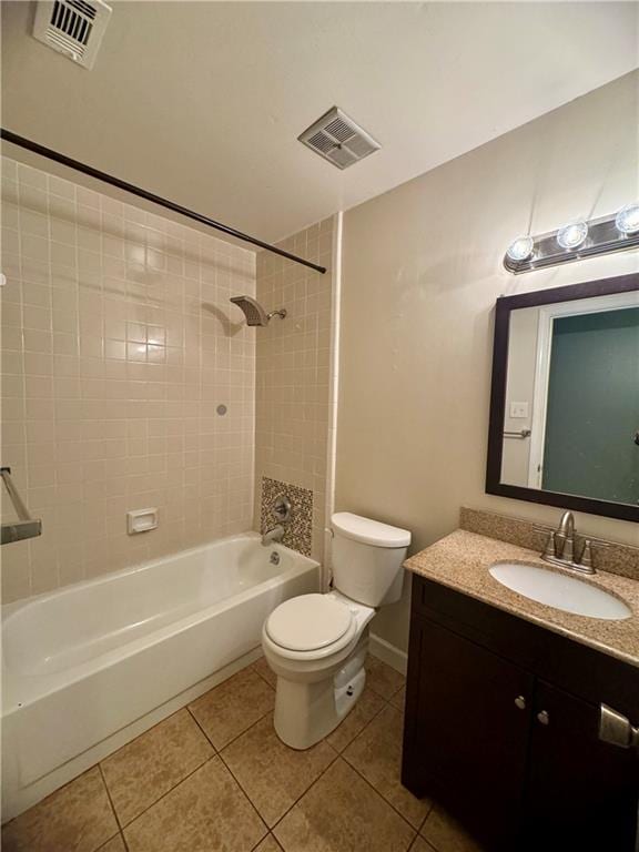 full bathroom featuring vanity, tile patterned floors, tiled shower / bath, and toilet