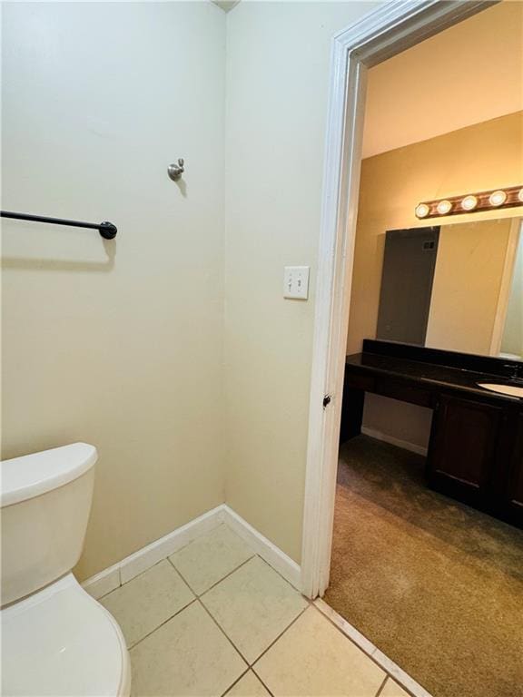 bathroom with tile patterned flooring, vanity, and toilet