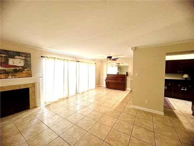 unfurnished living room featuring ceiling fan, light tile patterned floors, a tiled fireplace, and ornamental molding