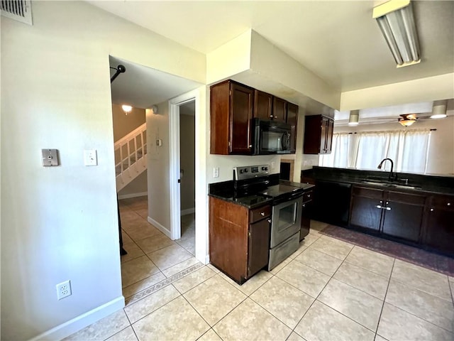 kitchen featuring dark brown cabinetry, light tile patterned floors, sink, and electric range