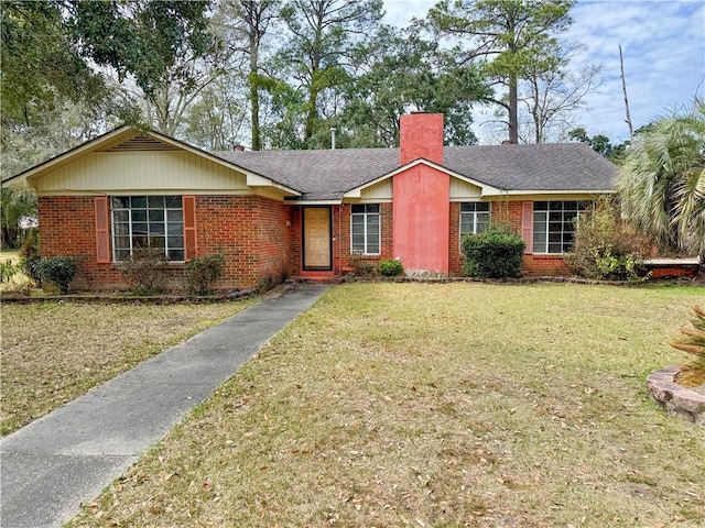 single story home featuring a front yard, a shingled roof, a chimney, and brick siding