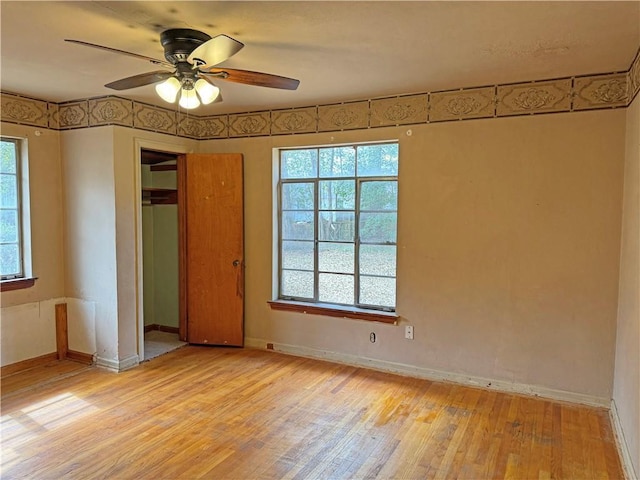 unfurnished bedroom with light wood-style floors, a ceiling fan, baseboards, and a closet