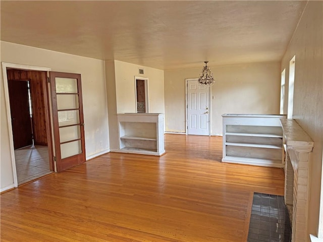 empty room featuring a chandelier and wood finished floors