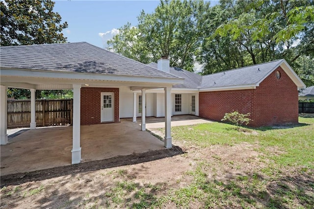 9996 Wedgefield Ct, Mobile, AL 36608 - rear view of property with brick siding, a chimney, a patio, a shingled roof, and a carport