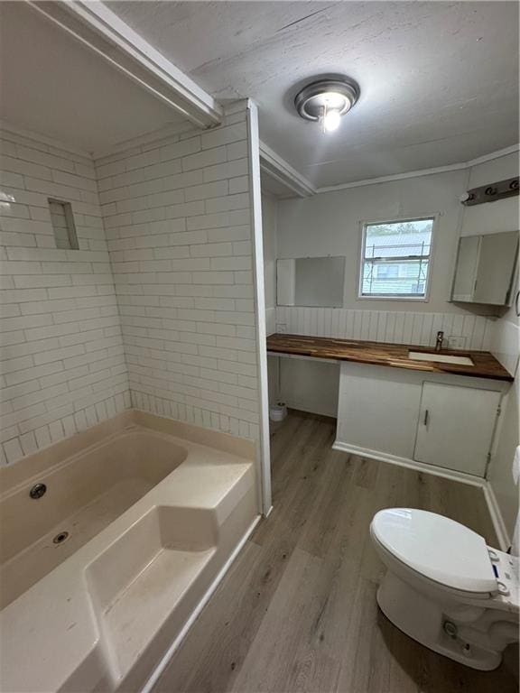 full bathroom with vanity, wood-type flooring, tiled shower / bath combo, and toilet