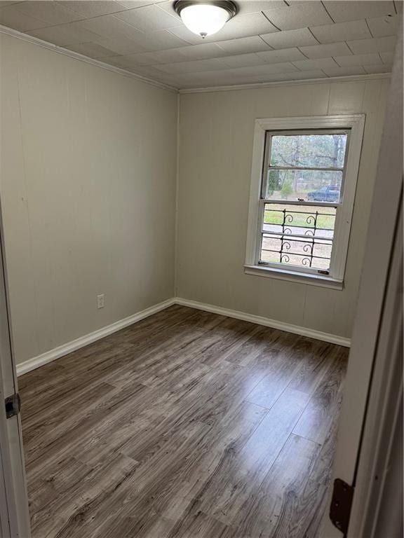 empty room featuring dark hardwood / wood-style flooring and ornamental molding