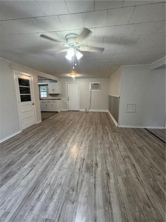 unfurnished living room featuring wood-type flooring and a wall mounted AC