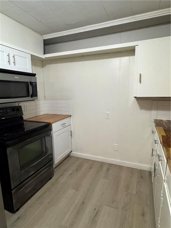 kitchen featuring white cabinets, butcher block countertops, black / electric stove, and light hardwood / wood-style floors