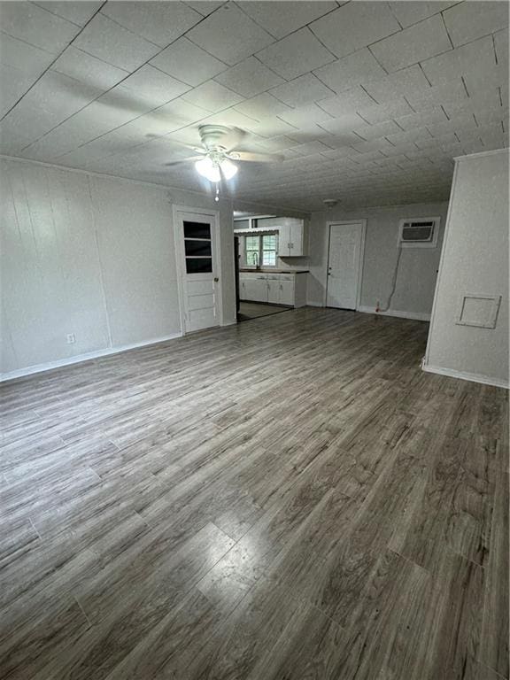 unfurnished living room featuring hardwood / wood-style flooring and a wall mounted air conditioner