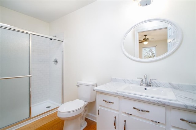 full bathroom featuring a stall shower, toilet, and vanity