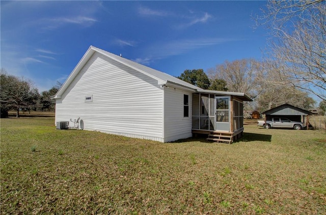 view of property exterior featuring a lawn, central AC, and a sunroom