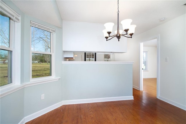 interior space with wood finished floors, baseboards, and a wealth of natural light